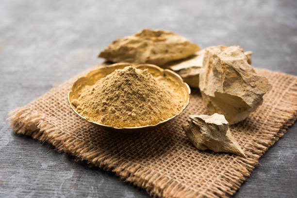 Fuller'S Earth Clay OR Multani mitti in a bowl along with raw stones and mortar